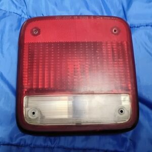 "Front view of 1985-1995 Chevy G20 passenger side tail light with red lens and clear bottom reverse section"