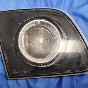 "Front lens view of 2004-2009 Mazda 3 Sedan driver left inner trunk tail light with clear lens, black bezel, and chrome ring reflector"