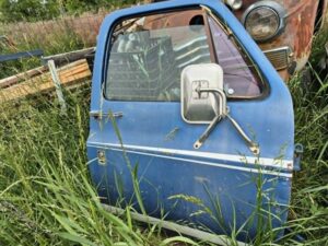"Driver side door for a 1973–1987 Chevy or GMC Square Body truck, blue finish with pinstripes, manual windows, tripod mirror, requires minor body work on front edge, as seen