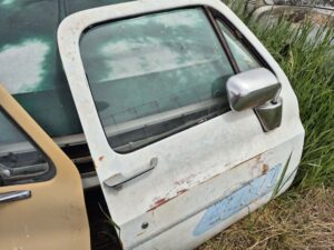 "Passenger side door for a 1973–1987 Chevy or GMC Square Body truck, white finish with graphics, features manual window setup, stainless mirror, and minor body filler work