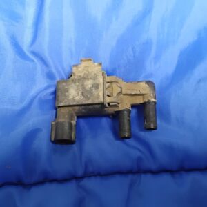 Side view of OEM Ford 6.4 Powerstroke turbo boost control solenoid showing vacuum hose nipples and electrical plug