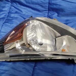 Front angle view of Mitsubishi Mirage passenger headlight with clear lens and amber reflector